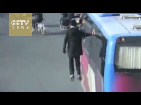 شاهد صينى يعلق نفسه على نافذة أتوبيس ويلوح للمارة